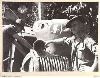 WEWAK AREA, NEW GUINEA. 1945-06-27. LANCE CORPORAL S.A. CRAWFORD (1) AND SAPPER D.H. HANNAN (2) MEMBERS OF 2/1 FIELD COMPANY, ROYAL AUSTRALIAN ENGINEERS, WORKING ALONGSIDE A RECAPTURED 8 DIVISION ..