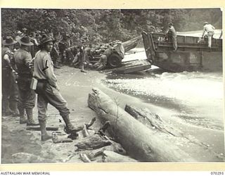 KELANOA ASND BUTUBUTU, NEW GUINEA, 1944-02-08. MEMBERS OF THE 2/14TH FIELD REGIMENT LOADING 25 POUNDER- GUNS ON A LANDING CRAFT MECHANIZED FOR THE ATTACK ON JAPANESE POSITIONS NEAR MALAMAI