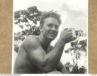 DONADABU, NEW GUINEA, 1943-11-03. PORTRAIT OF A BARE-CHESTED QX52854 LANCE CORPORAL W.H. SMITH OF NO. 3 PLATOON, 18TH AUSTRALIAN FIELD COMPANY, ROYAL AUSTRALIAN ENGINEERS, ENJOYING A MUG OF TEA ..