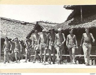 PAPUA, NEW GUINEA. 1942-08. YOUTHFUL AUSTRALIAN SOLDIERS MANNING A FORWARD POST IN NEW GUINEA HAVE TAKEN UP RESIDENCE IN A DESERTED NATIVE VILLAGE. THIS PICTURE SHOWS THEM SETTING OUT FOR A SWIM IN ..