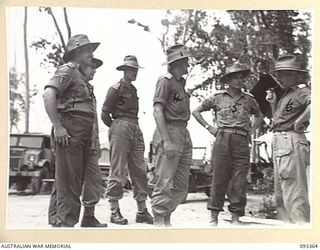 PALMALMAL PLANTATION, NEW BRITAIN, 1945-06-23. AN ADVANCE PARTY OF HQ 11 DIVISION CAME FROM AUSTRALIA TO TAKE OVER FROM HQ 5 DIVISION. ABOVE A GROUP OF HQ 5 DIVISION OFFICERS WAITING AT THE ..