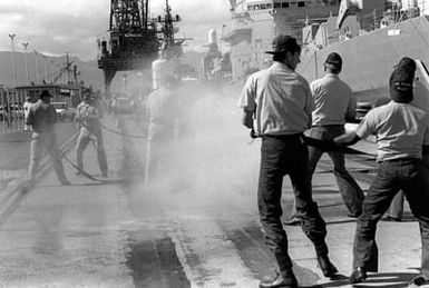 Crewmen test fire hoses during Damage Control Olympics at the Bravo Piers