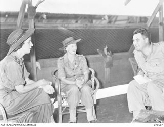 BOUGAINVILLE ISLAND. 1945-01-23. NX78467 LIEUTENANT IAN B. AIRD, DIRECTOR OF PUBLIC RELATIONS, LAND HEADQUARTERS (3) CHATTING WITH QFX19161 SISTER E.M. ALLEN (1) AND QFX19159 SISTER E.M. DUFFIELD ..