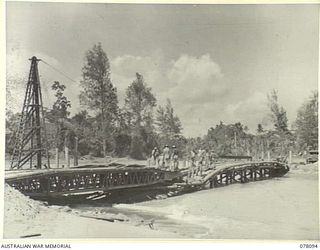 AITAPE, NEW GUINEA. 1944-12-26. PERSONNEL OF THE 2/14TH FIELD COMPANY, USING A SECTION OF A SMALL BOX GIRDER TO REPAIR A FLOOD DAMAGED BRIDGE ACROSS THE RIVER EAST OF THE TOWN