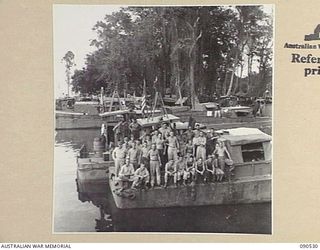 JACQUINOT BAY, NEW BRITAIN. 1945-04-12. PERSONNEL OF 3016 ENGINEER BOAT MAINTENANCE COMPANY (US ARMY), ATTACHED HQ 5 DIVISION LINED UP ON THE END OF ONE OF THEIR REPAIR BARGES