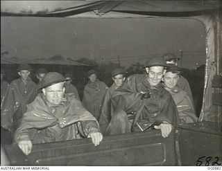 KIRIWINA, TROBRIAND ISLANDS, PAPUA. C. 1944-02. HAIL, RAIN OR SHINE, RAAF GUARDS IN THE NEW GUINEA AREA ARE ON THE JOB DAY AND NIGHT. CLIMBING INTO THE TRUCK, GUARDS GOING ON DUTY DURING THE ..