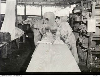 VIVIGANI, GOODENOUGH ISLAND, PAPUA. C. 1943-10. IN THE PARACHUTE SECTION, NO. 30 BEAUFIGHTER SQUADRON RAAF. THIS CHUTE HAS JUST BEEN RETURNED FOR AN INSPECTION AFTER AN OPERATIONAL FLIGHT IN WHICH ..