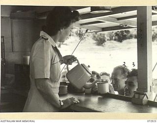 KILA BEACH, PORT MORESBY, NEW GUINEA. 1944-05-11. V2/362 MRS N. LYNCH (1), A MEMBER OF THE AUSTRALIAN RED CROSS ATTACHED TO THE 2/1ST GENERAL HOSPITAL, POURING TEA FROM A MOBILE CANTEEN WHICH ..