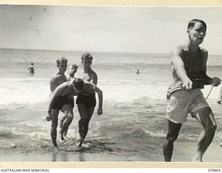 TOROKINA, BOUGAINVILLE ISLAND. 1945-01-28. A "PATIENT" BEING BROUGHT ASHORE DURING AN EXAMINATION OF AUSTRALIAN ARMY PERSONNEL FOR THEIR BRONZE LIFE SAVING MEDALLION