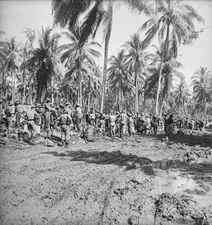 FINSCHHAFEN AREA, NEW GUINEA. 1943-11-13. TROOPS WAITING AT LAUNCH JETTY FOR THE ORDER TO MOVE FORWARD