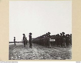 CAPE WOM, NEW GUINEA, 1945-09-13. TROOPS OF 6 DIVISLION PRESENT ARMS AT THE SURRENDER CEREMONY HELD AT CAPE WOM AIRSTRIP WHERE LIEUTENANT-GENERAL H. ADACHI, COMMANDER 18 JAPANESE ARMY IN NEW GUINEA ..