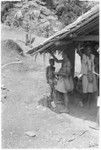 People hanging up money by side of house in what is probably a compensation payment