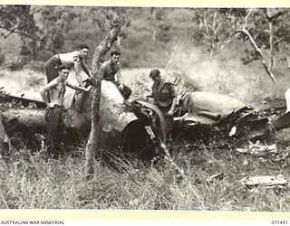PIONEER CROSSING, PORT MORESBY AREA, PAPUA, 1944-03-25. AUSTRALIAN SERVICEMEN AT THE WRECK OF A P.38 LIGHTNING FIGHTER AIRCRAFT OF THE UNITED STATES ARMY AIR FORCE WHICH CRASHED IN TIMBERED AREA ..