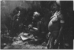 Pig festival, uprooting cordyline ritual, Tsembaga: men butcher pig that has been sacrificed to spirits of high ground