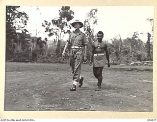 TOL, NEW BRITAIN, 1945-08-04. LIEUTENANT J.M. MOORE, 1 NEW GUINEA INFANTRY BATTALION WITH A SEPIK NATIVE AT HEADQUARTERS. MOORE WAS A MEMBER OF THE AUSTRALIAN MISSION 204 IN CHINA IN 1942
