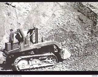 WAU-LABU ROAD, NEW GUINEA, 1946-01-09. A TD9 FRONT END LOADER ABOUT TO LOAD RECOVERED GRAVEL INTO A TIPPER TRUCK FIFTY-EIGHT MILES FROM LABU. THE VEHICLES ARE OPERATED BY MEMBERS OF 8 MECHANICAL ..