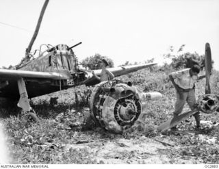 BUT AREA, DAGUA, NORTH EAST NEW GUINEA. C. 1945-04. FLIGHT LIEUTENANT L. F. GREEN RAAF OF LINDFIELD, NSW (RIGHT), IS INSPECTING THE AIRSCREW OF A PARTLY DISMANTLED JAPANESE NAKAJIMA KI-43, ARMY ..