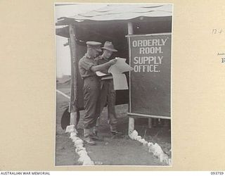 CAPE WOM, WEWAK AREA, NEW GUINEA, 1945-07-02. CAPTAIN L.J. TINKER, OFFICER COMMANDING 2/22 SUPPLY DEPOT PLATOON (1) WITH WARRANT OFFICER 2 C. ROSS, DEPOT SUPERINTENDENT (2) DISCUSSING THE ARRIVAL ..