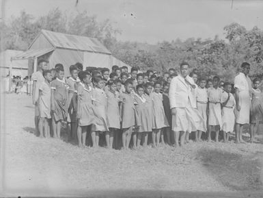 [A large group of Pacific Island children in uniform standing to attention]