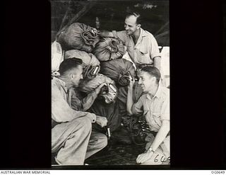 PAPUA-NEW GUINEA AREA. 1944-02-04. LEADING AIRCRAFTMAN (LAC) K. G. WILLIAMSON, MORNINGTON, VIC, LAC A. H. MOORE AND CORPORAL S. A. PARSONS WITH THE CARGO IN A RAAF DOUGLAS C47 DAKOTA TRANSPORT ..