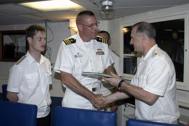 During the Passing Exercise (PASSEX) 2006, Santa Rita, Guam (GU), the CHIEF of STAFF and First Deputy Commander of the Pacific Fleet of the Russian Federation Navy (RFN), Vice Admiral (VADM) Konstantin Sidenko, presents a Russian Pacific Fleet photo book to the USN Arleigh Burke Class Guided-missile Destroyer USS CHUNG-HOON (DDG 93) Commanding Officer (CO), Commander (CDR) Dave Welch, after a tour of the RFN ship