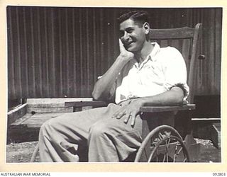 LAE, NEW GUINEA. 1945-06-09. SERGEANT J. HOWLIE, SITTING IN HIS WHEELCHAIR WAITING TO BE MOVED WITH OTHER 2/7 GENERAL HOSPITAL PATIENTS TO THE HOSPITAL SHIP MANUNDA