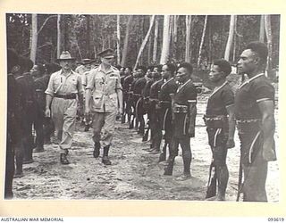 JACQUINOT BAY, NEW BRITAIN, 1945-07-02. HIS ROYAL HIGHNESS, THE DUKE OF GLOUCESTER, GOVERNOR-GENERAL OF AUSTRALIA (2), ACCOMPANIED BY LIEUTENANT L.D. DEAN, COMMANDER OF THE GUARD (1), INSPECTING A ..