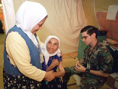 US Air Force AIRMAN First Class (A1C) George Hildebrand, Yokota Air Base, Japan, administers immunization shots to a Kurdish woman at Andersen Air Force Base, Guam, during OPERATION PACIFIC HAVEN. Pacific Haven, a joint humanitarian operation conducted by the U.S. Military, evacuated over 2,100 Kurds from Northern Iraq. The evacuees will be housed temporarily at Andersen AFB, Guam, while they go through the immigration process for residence into the United States