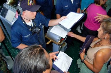 U.S. Navy (USN) SEAMAN Timothy Conklin signs honorary surface warrior qualification cards for guests during a Friends and Family Cruise aboard the USN L.Y. Spear Class Submarine Tender USS FRANK CABLE (AS 40) on Dec. 1, 2006. The cruise allowed guests to see what their Sailors do while they're out to sea. The sub tender is forward deployed to Apra Harbor, Guam, in support of submarines that deploy to the western Pacific. (U.S. Navy photo by Mass Communication SPECIALIST First Class Jeremy Johnson) (Released)