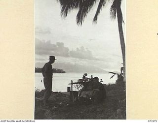 SARANG, NEW GUINEA. 1944-05-25. NX156376 LIEUTENANT E.A. THEW (1), AND S112111 PRIVATE A.J. LING (2), MEMBERS OF THE 35TH INFANTRY BATTALION, RELAX BESIDE THEIR FIRE AT DUSK DURING THE UNIT DRIVE ..