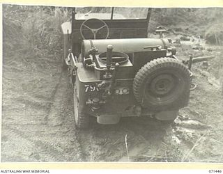 PIONEER CROSSING, PORT MORESBY AREA, PAPUA, 1944-03-25. A JEEP OF THE 2/107TH MOBILE BATH UNIT. THE POSITION OF THE BOILER, THE BURNER, AND THE DISMANTLED SHOWERS CAN BE SEEN