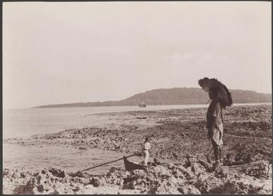 Man standing on rocks at the landing place of Loh with Southern Cross in background, Torres Islands, 1906 / J.W. Beattie