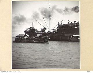 BORAM, NEW GUINEA, 1945-08-06. AUSTRALIAN LANDING CRAFT WORKING WITH HQ COMMAND, AUSTRALIAN ARMY SERVICE CORPS, 6 DIVISION, UNLOADING SUPPLIES FROM THE OCEAN FREIGHTER FOR TRANSPORT TO THE SHORE