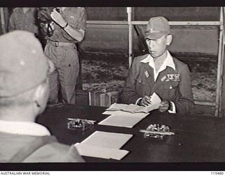 TOROKINA, BOUGAINVILLE. 1945-09-08. LIEUTENANT-GENERAL M. KANDA, COMMANDER, 17TH JAPANESE ARMY, READING THROUGH THE SURRENDER DOCUMENTS DURING THE SURRENDER CEREMONY AT HQ 2 CORPS
