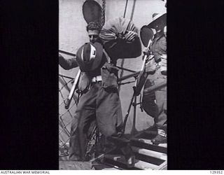 SYDNEY, NSW. 1946-05-16. NX173383 PRIVATE A. MUNRO, 2/4TH INFANTRY BATTALION, RETURNING HOME LADEN WITH GEAR, COMING DOWN THE GANGPLANK OF THE TROOPSHIP CANBERRA, AFTER HER ARRIVAL FROM RABAUL