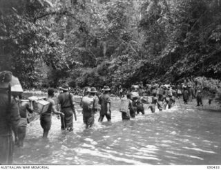 WONGINARA MISSION, NEW GUINEA. 1945-04-04. NATIVES CARRYING SUPPLIES ALONG A KAI (FOOD) LINE ALONG THE MABAM RIVER TO FORWARD 2/3 INFANTRY BATTALION TROOPS IN THE TORRICELLI MOUNTAINS. THE LINE WAS ..