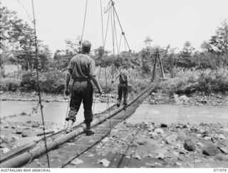 LAE, NEW GUINEA. 1944-04-01. A 300 FEET SUSPENSION BRIDGE CONSTRUCTED BY ROYAL AUSTRALIAN ENGINEERS, HEADQUARTERS LAE BASE SUB AREA, CARRIES A PIPELINE WHICH PROVIDES WATER TO HOSPITALS