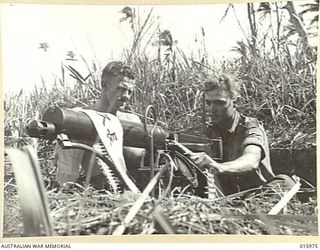 1943-10-21. NEW GUINEA. RAMU VALLEY. PRIVATE (PTE) CHARLES NEIL OAKHAM OF DUNGOG, NSW, AND PTE ARCHIBALD MCCREADY SEMPLE OF BRISBANE, QLD,  MAN A VICKERS GUN IN THE RAMU VALLEY. ACROSS THE GUN IS ..