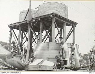 MADANG, NEW GUINEA. 1944-08-25. TROOPS OF THE 55TH FIELD PARK COMPANY, ERECTING ONE OF A SERIES OF FOUR 5000 GALLON WATER TANKS AT THE NEW SITE OF THE 2/11TH GENERAL HOSPITAL. IDENTIFIED PERSONNEL ..