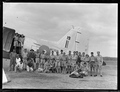 Portrait of unidentified RNZAF personnel in front of NZ3517 C47 transport plane at [Fua'Amotu?] Airfield, Tonga