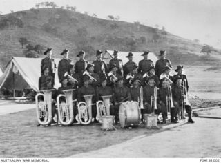 Group portrait of 25 members of 2/22 Battalion Regimental Band, 23 of whom were originally members of Salvation Army bands who had enlisted in 1940. The battalion served as a garrison force at ..