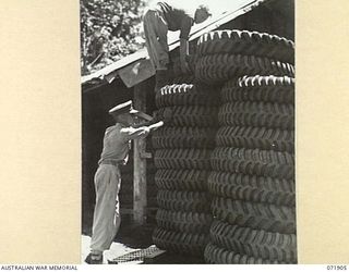 LAE, NEW GUINEA. 1944-03-30. TRUCK TYRES POSITIONED IN PILLARS OUTSIDE A STORE AT NO. 1 SUBSECTION, 103RD FIELD AMMUNITION DEPOT