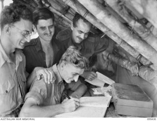 KIARIVU, NEW GUINEA, 1945-08-15. MEMBERS OF 2/7 INFANTRY BATTALION, CORPORAL B.A. WILLIAMS (1), PRIVATE H. CAMERON (2) AND LANCE-SERGEANT C.G. BROADBENT (3) WITH SERGEANT S. FYFE (4) WHO IS ..