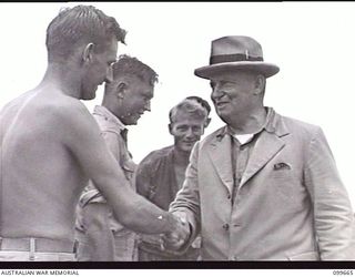 LAE AIRSTRIP, NEW GUINEA, 1946-01-27. THE HONOURABLE F. M. FORDE, MINISTER FOR THE ARMY, TALKING TO MEMBERS OF THE RAAF, ON HIS ARRIVAL AT THE AIRSTRIP FOR AN INSPECTION TOUR OF AUSTRALIAN UNITS IN ..