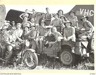 1942-11-19. NEW GUINEA. ALLIED TROOPS POSE ON THE FIRST JEEP AND THE FIRST MOTOR CYCLE TO BE LANDED A C47 TRANSPORT AIRCRAFT. (NEGATIVE BY G. SILK)