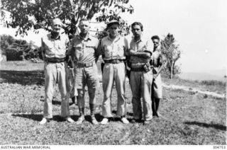 FINSCHHAFEN, PAPUA. 1942-12. GROUP PORTRAIT OF COASTWATCHERS. LEFT TO RIGHT: LIEUTENANT K. C. DOUGLAS; WARRANT OFFICER A. P. H. FREUND; SERGEANT J. CHAMPAGNE, USAAC; RADIO AIR GUNNER GRAHAM, USAAC. ..