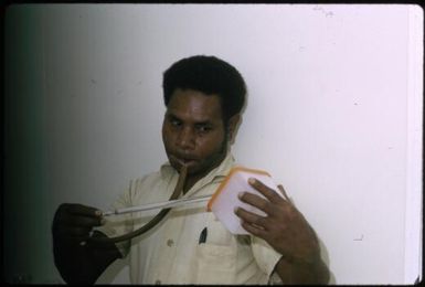 Joe extracting adult anopheline mosquitoes from cages : Bougainville Island, Papua New Guinea, April 1971 / Terence and Margaret Spencer