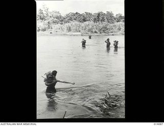 PAPUA, 1943-01-14. AMERICAN TROOPS WADE ACROSS A RIVER NEAR SOPUTA