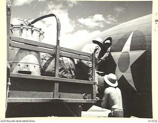 1942-12-02. NEW GUINEA. HOSPITAL EQUIPMENT BEING LOADED INTO A TRANSPORT PLANE IN WHICH IT WILL BE FLOWN TO AN ADVANCED BASE WHERE WOUNDED WILL BE TREATED WHILST AWAITING TRANSPORT. (NEGATIVE BY G. ..