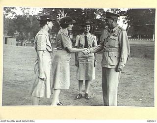 INDOOROOPILLY, QUEENSLAND. 1945-04-23. MAJOR GENERAL C.H. SIMPSON, (2), SHAKES HANDS WITH LIEUTENANT R.W. HENNESSY, (1), WHO WILL BE IN CHARGE OF A DRAFT OF PERSONNEL MOVING FROM 2 AUSTRALIAN ..